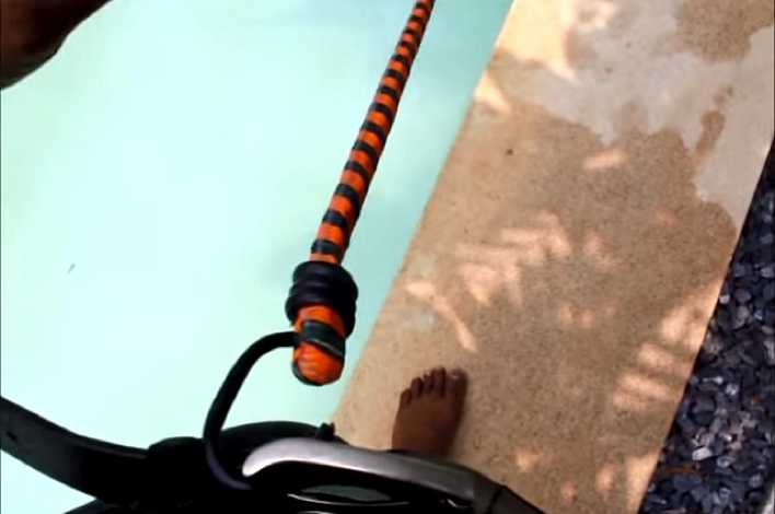 He Hooks A Cable To His Belt. When He Jumps Into The Pool? Genius!